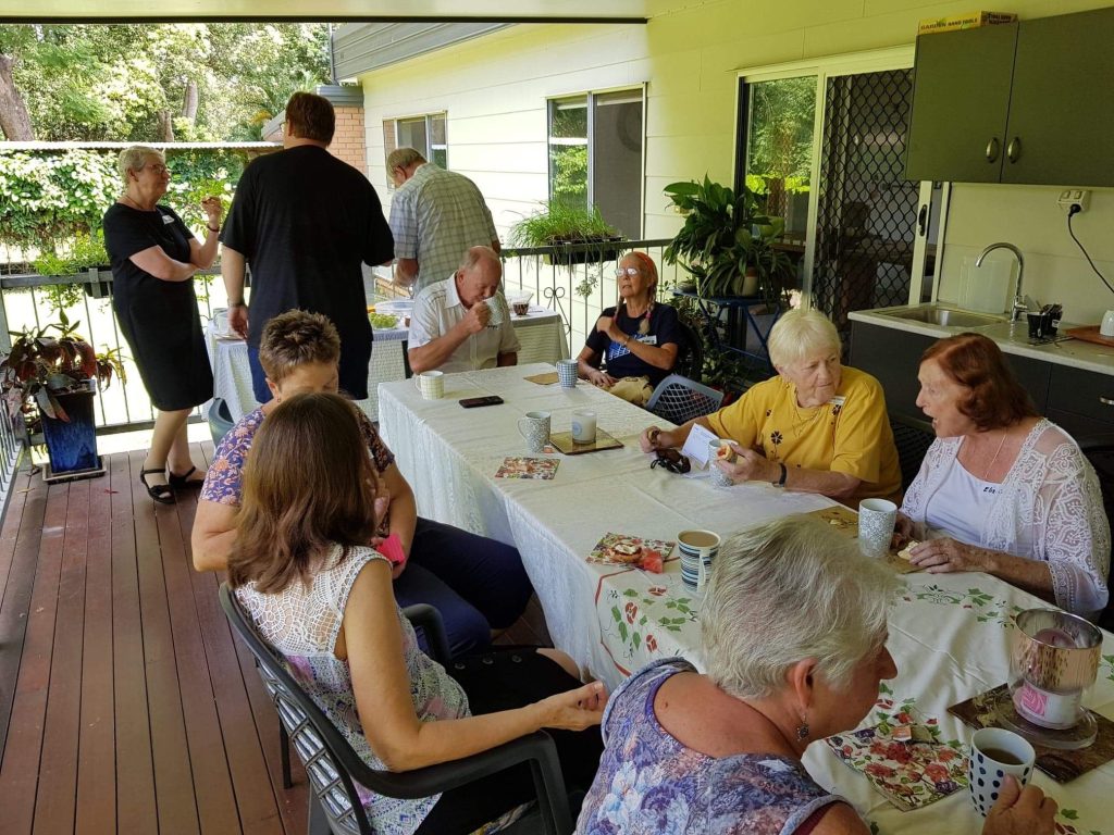 Abbey-Retreat.workshop-events (4) Candid outdoor community
group photo. People
around a table, greenery
visible.