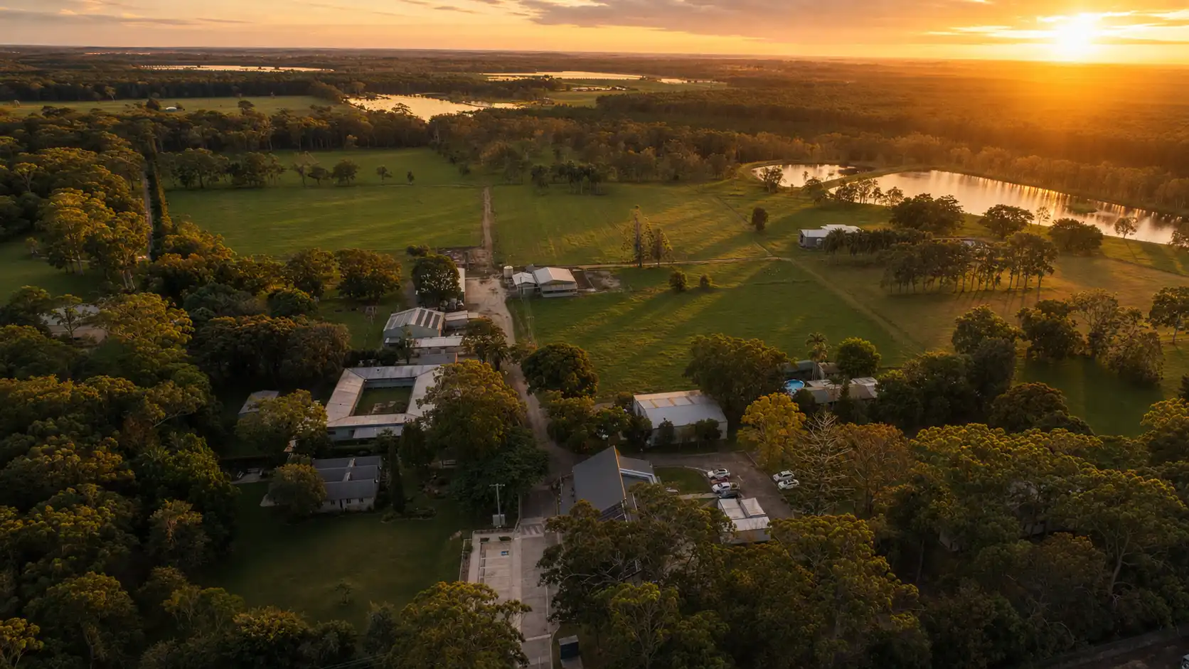 Aerial view of Abbey Community precinct and surrounding grounds. Golden hour, open sky.